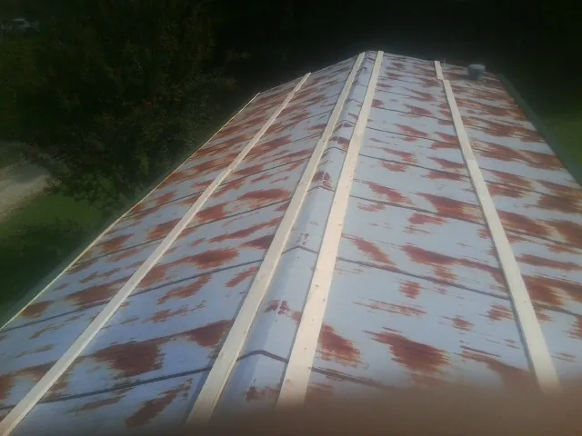 Rusted metal roof panels with new wood purlins before replacement — Storm Damage Roof Repair in Burton by Roofing Brothers
